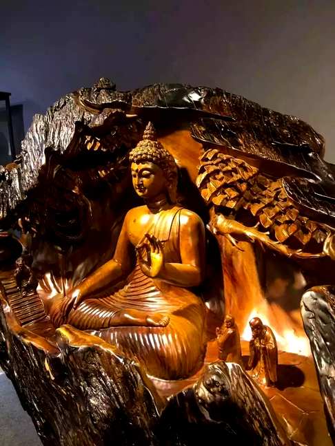 《泰国大佛》作品用一整根千年楠木树根依形状雕琢而成以大佛为主体以住持和